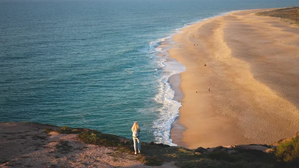 Tourist Girl Stands at Rock of Fort of Sao Miguel Arcanjo Looks at Nazare Beach