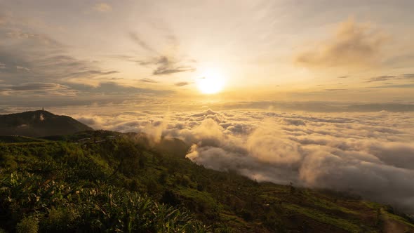 Time lapse of aerial view of sunset above fluffy sea fog misty clouds with mountain alt