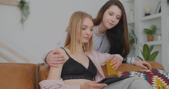 Lesbians are on the couch Two lesbians are in an apartment Two lesbians are hugging LGBT Bisexual