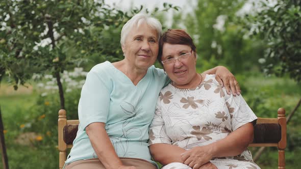 Two Elderly Women Smiling Looking at the Camera. alt