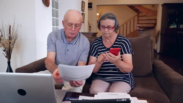 Senior Couple Calculating Bills Cost at Home