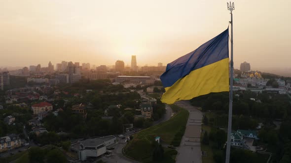 Aerial View of the Ukrainian Flag Waving in the Wind Against the City of Kyiv alt