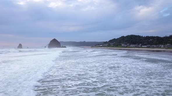 Aerial low drone flying at Cannon Beach in Oregon and Haystack Rock. alt