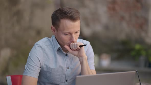 Portrait of a Brooding Man Sitting with a Laptop and Planning to Solve Problems and Brainstorming alt