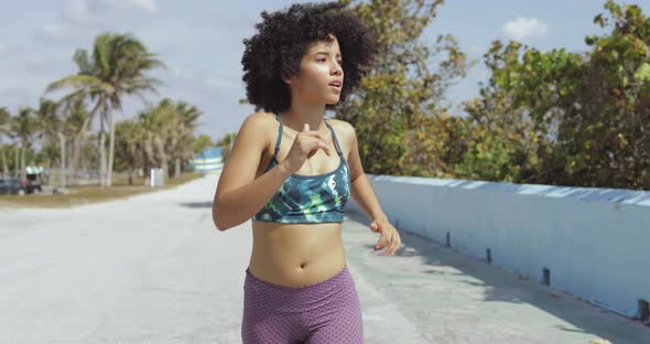 Black Fit Girl Jogging on Tropical Waterfront alt