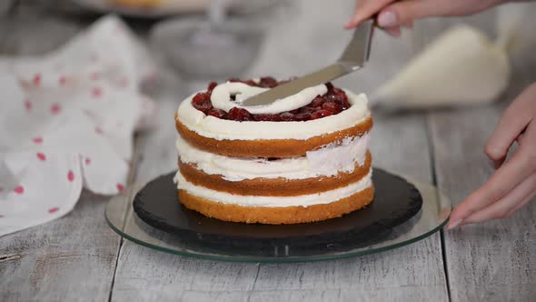 Female Chef Confectionery Making a Cake with a Cherry and Vanilla Cream
