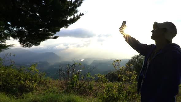 Man Taking Selfies in Mountains When the Sun Rises Beautiful Landscape. Memories of Vacation