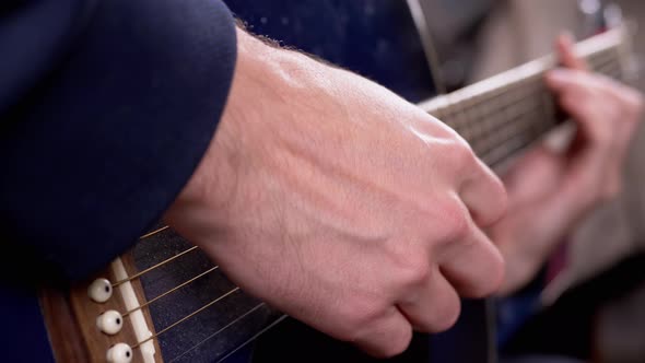Guitarist Male Fingers Play Strings of an Acoustic Guitar at Home alt