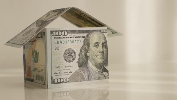 Slow tilt on dollar paper currency improvised house 4K 2160p 30fps UltraHD tilting footage - Hundred alt