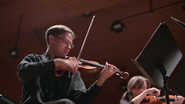 Violinist in black clothes plays the violin to the accompaniment alt