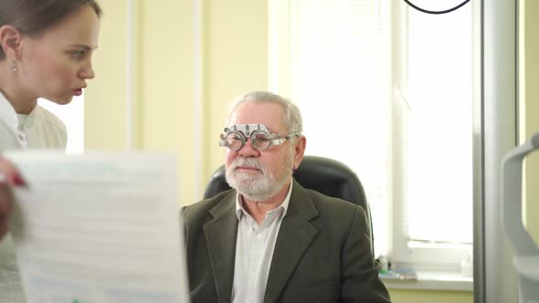 Ophthalmologist Makes Selection of Lenses Diagnoses a Elderly Man's Vision alt