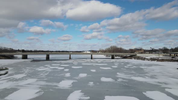 Bridge spanning frozen river in Wisconsin. Brilliant sunny winter day.