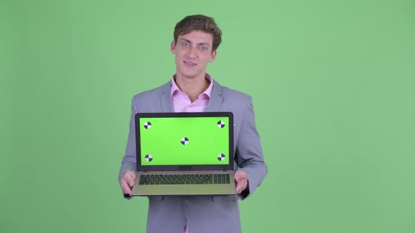 Happy Young Businessman Talking While Showing Laptop alt