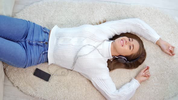 European Teenage Woman Wearing White Winter Sweater Having Fun Listening Music Using Headphones alt