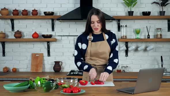 Woman listen chef study online video call sliced bell pepper on cutting board alt