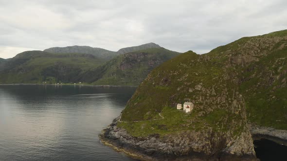 Distant View Of Coastal Hendanes Lighthouse At The Top Of The Cliff In Vagsoy Island, Norway. aerial alt