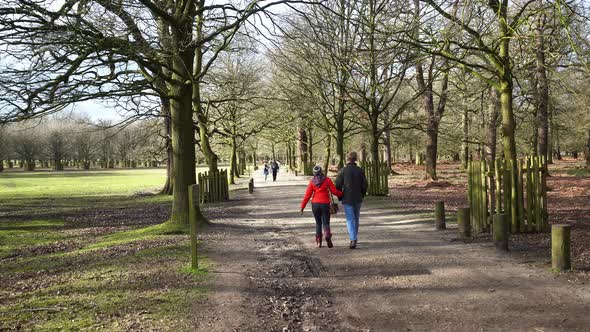 A couple walk arm in arm, together at Dunham Massey a Georgian house, garden for all seasons and an alt