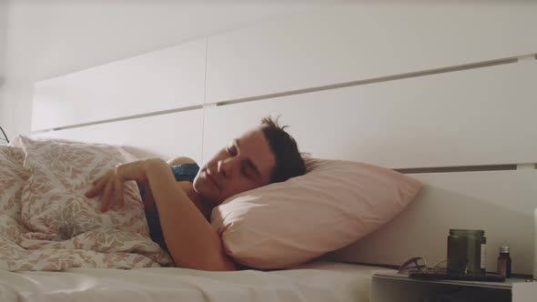 Transgender Man Waking Up and Using Smartphone in Bedroom alt