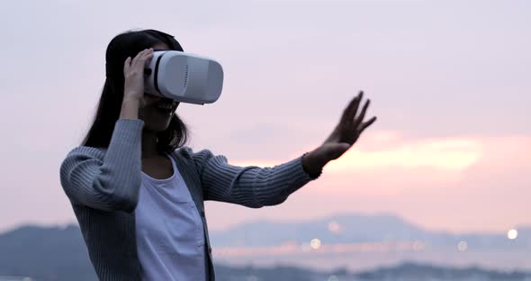 Woman uses a virtual reality glasses on the roof  alt