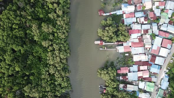 Aerial view river separate the mangrove forest and Malays housing village. alt