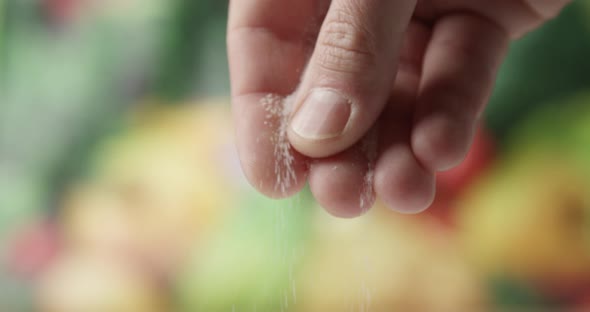 Close Up Of Male Fingers Salting With A Fine Salt And Food On The Background alt