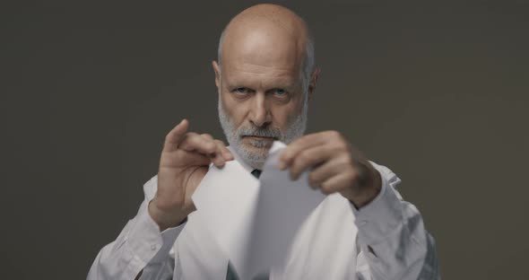 Businessman tearing a contract in pieces