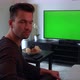 A Man Watches a TV with a Green Screen, Then Turns To the Camera and Shakes His Head, Unhappy - VideoHive Item for Sale