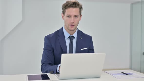 Attractive Young Businessman Looking at the Camera and Smiling alt