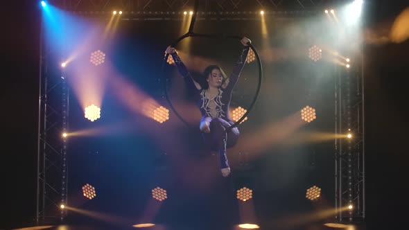 The Young Aerial Artist Woman Rotates Rapidly in an Aerial Circle. Filmed in a Dark Studio with alt