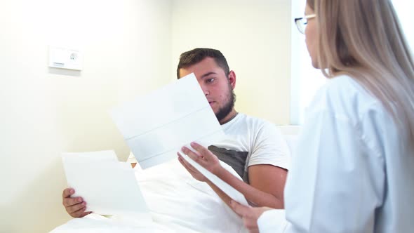 Dentist Showing X Ray Scans To Patient in Clinic