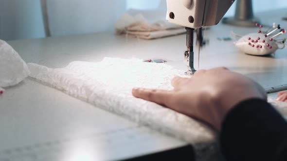 Young entrepreneur sewing wedding dress