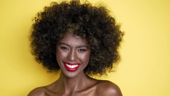 Black Woman with Afro Haircut and Red Lips Sending Air Kiss at Camera