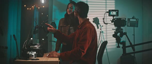 The filmmaker and the actress looking at the movie clips on the laptop alt