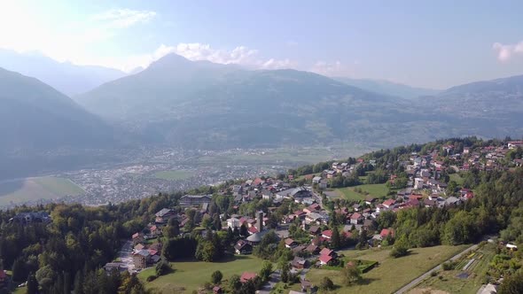 Aerial tilt down over a small village in the french Alps, Plateau d'Assy. Backlighting and autumn co alt