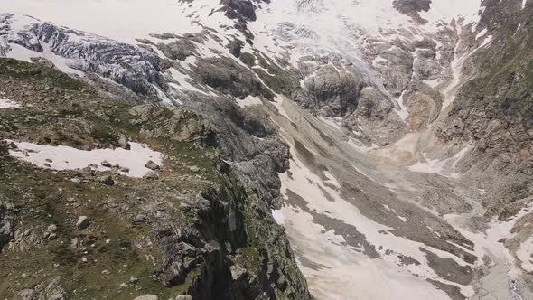 Glacier Covered with Stone Rocks Deep Cracks and Small Waterfalls alt