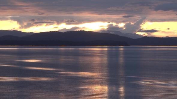 Sea cruise ship along the coast of Alaska. Colorful sunset in the mountains of Alaska. alt