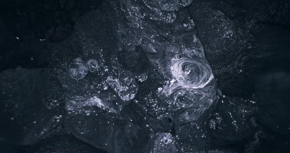 Closeup Silver Glitter Spreading in Black Water alt