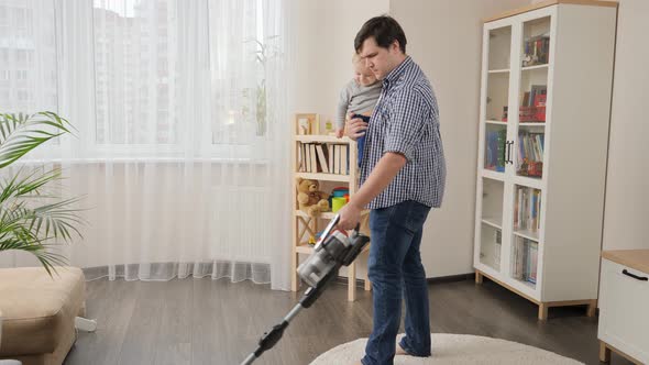 Father doing housework and cleanup with his little baby alt