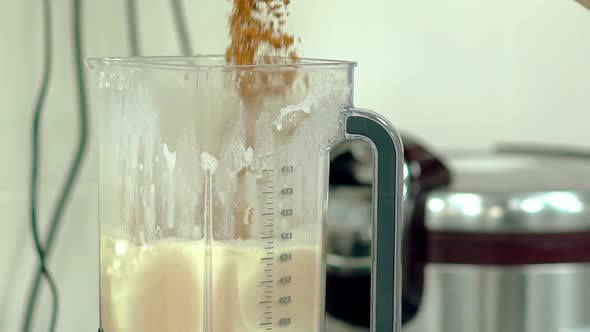 Cook Pours Cocoa Into the Mixer alt