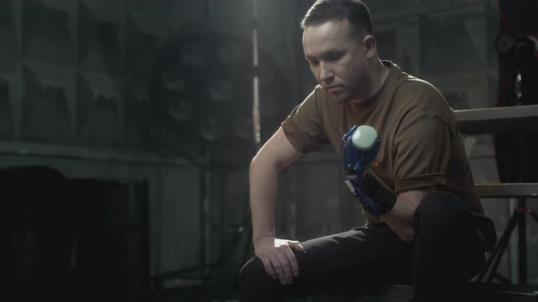 A Disabled Man with a Prosthetic Hand Raises a Dumbbell alt