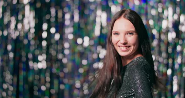 Portrait of a Young Beautiful Woman Wearing Brocade Dress Turning Around Smiles and Looking at you alt