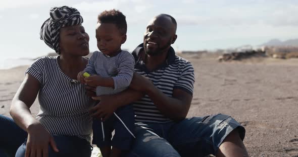 African child having fun with mother and father on the beach - Black family enjoy summer time alt
