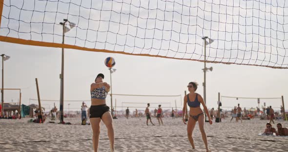 Slow motion of women playing beach volleyball during sunset alt