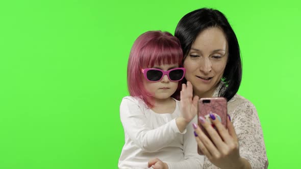Mother, Daughter Holding, Using Smart Phone Talking on Video Call. Social Media alt