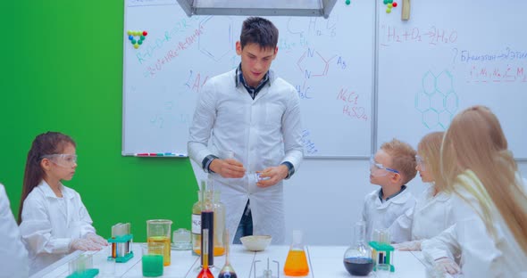 Pupils and Teacher Watching Experiment in Science Class alt
