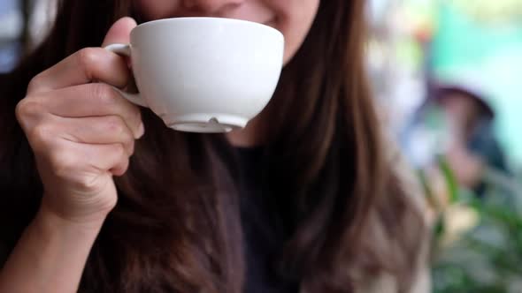 Slow motion of an asian woman enjoy drinking hot coffee