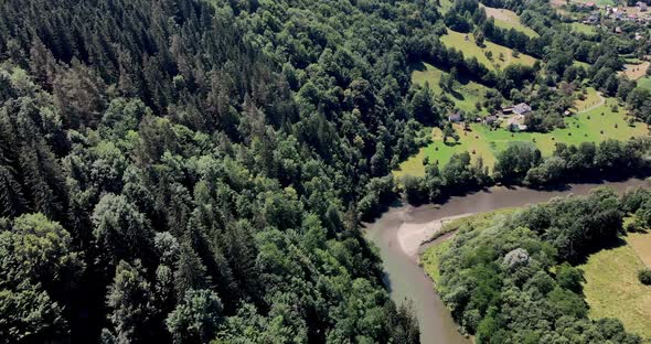 Aerial View Of The  Aries River Surrounded With Green Forest On Sunny Day In Romania. alt
