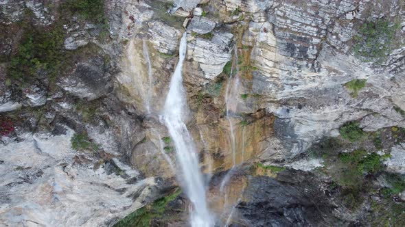 aerial footage above a falling water of a waterfall alt