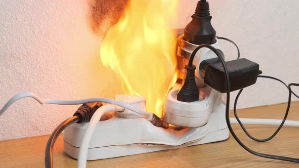 power strip with electrical plugs burns with open flame in room., Stock ...