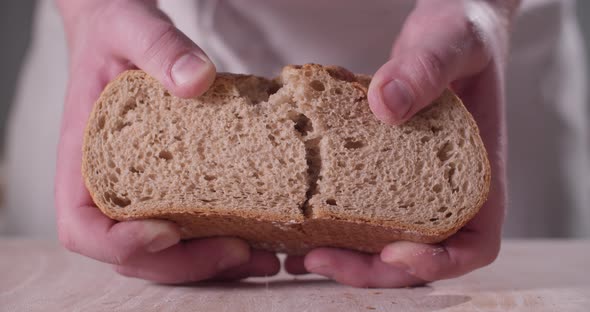 Close Up of Baker Hands Breaking Homemade Bread